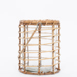 Side view. Glass Lieto Lantern with rattan exterior and handle in natural light wood tone. White background. 