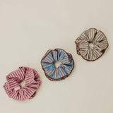 Three striped scrunchies on a beige background