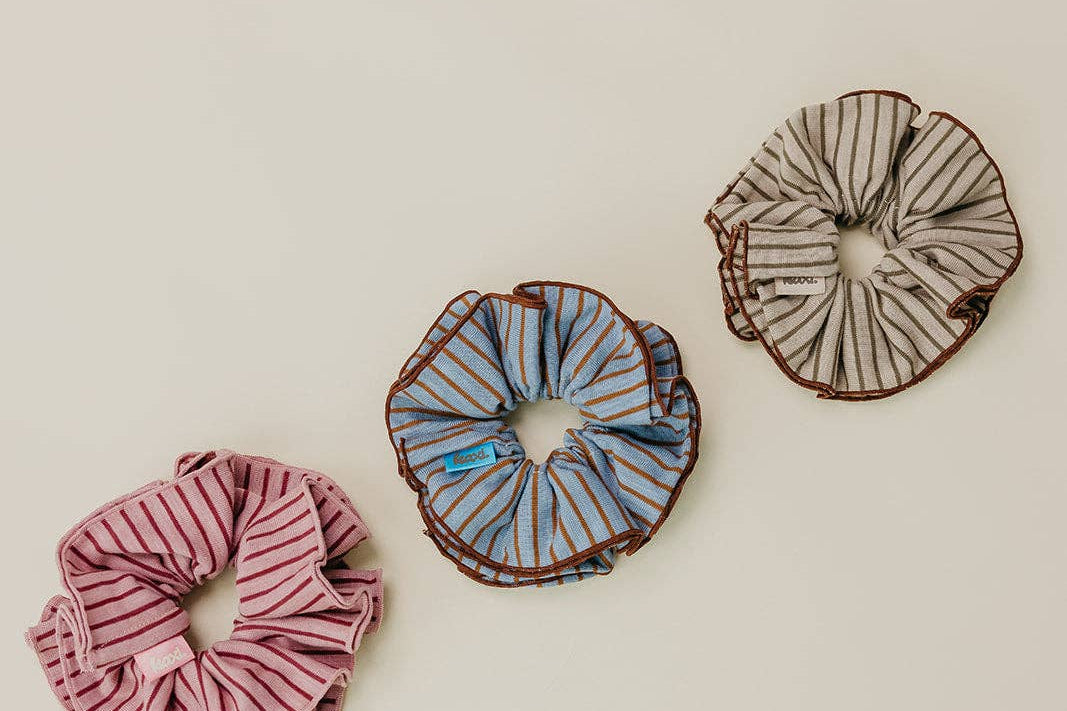 Three striped scrunchies on a beige background