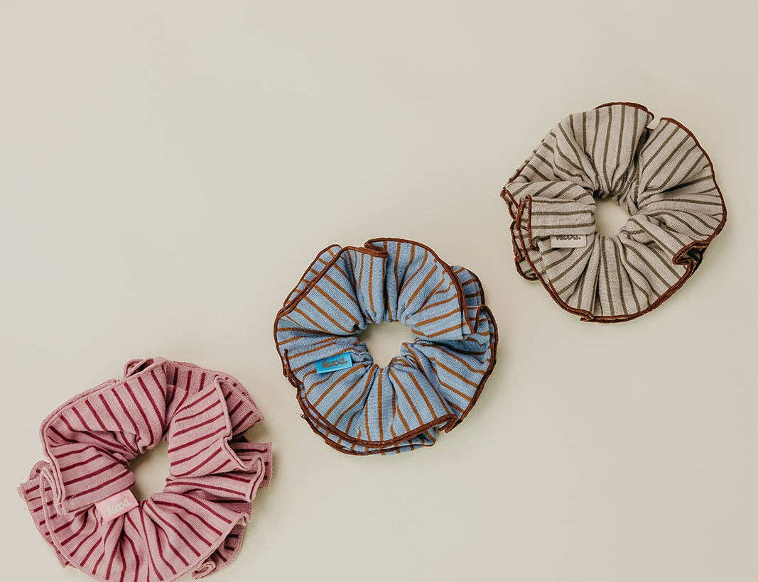 Three striped scrunchies on a beige background