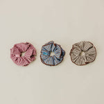 Three scrunchies on a beige background