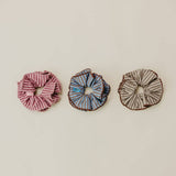 Three scrunchies on a beige background