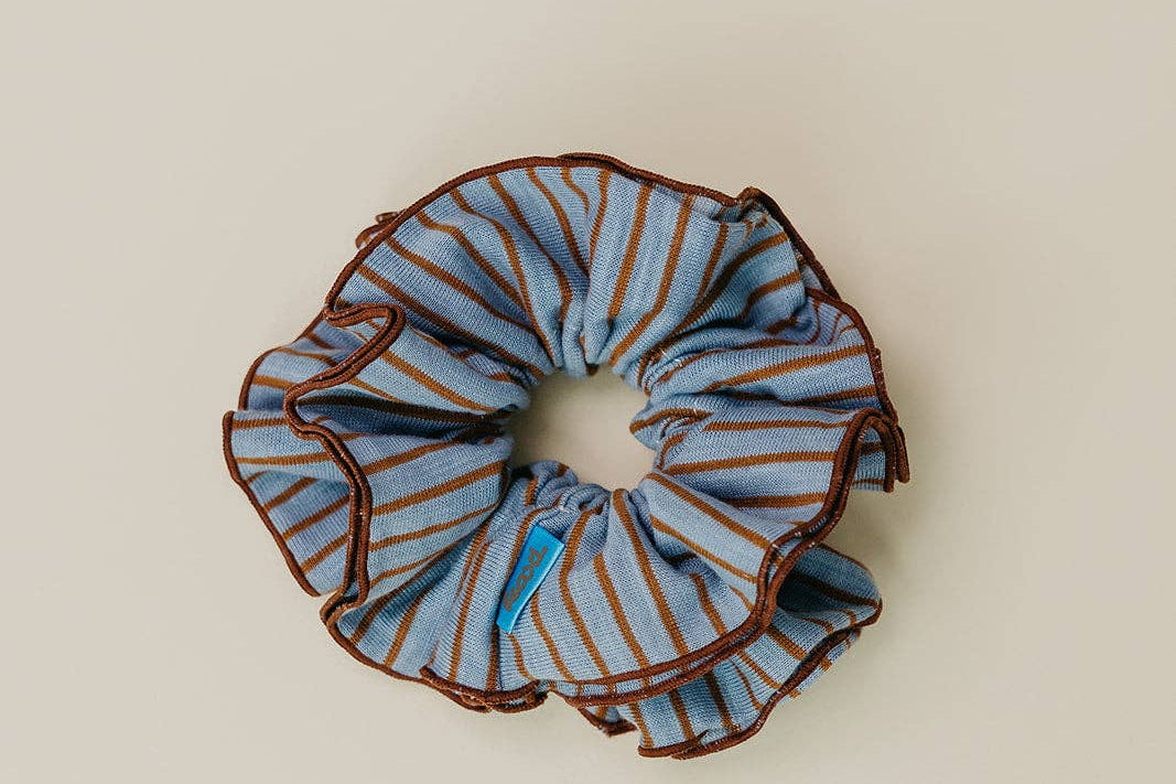 Blue and brown striped scrunchie on a beige background