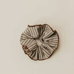 Black and white striped scrunchie on a beige background
