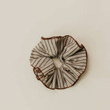 Black and white striped scrunchie on a beige background