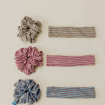 Set of striped headbands and scrunchies on a beige background