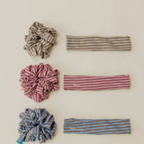 Set of striped headbands and scrunchies on a beige background