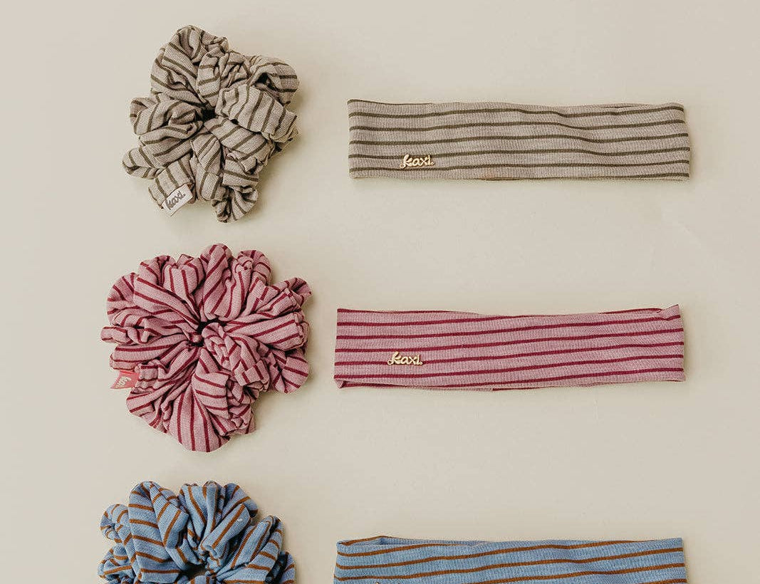 Set of striped headbands and scrunchies on a beige background