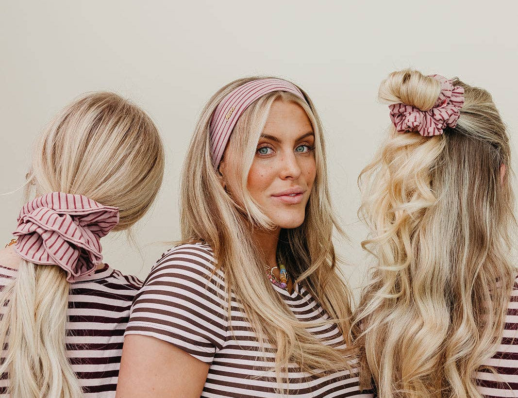 Three women in matching striped shirts with hairstyles using pink scrunchies.