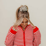 Person wearing a red and white striped jacket against a beige background