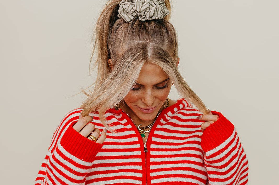 Person wearing a red and white striped jacket against a beige background