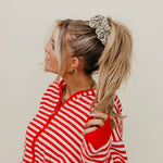 Woman wearing a red and white striped shirt with a neutral background