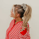 Woman wearing a red and white striped shirt with a neutral background