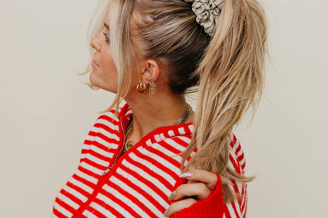Woman wearing a red and white striped shirt with a neutral background