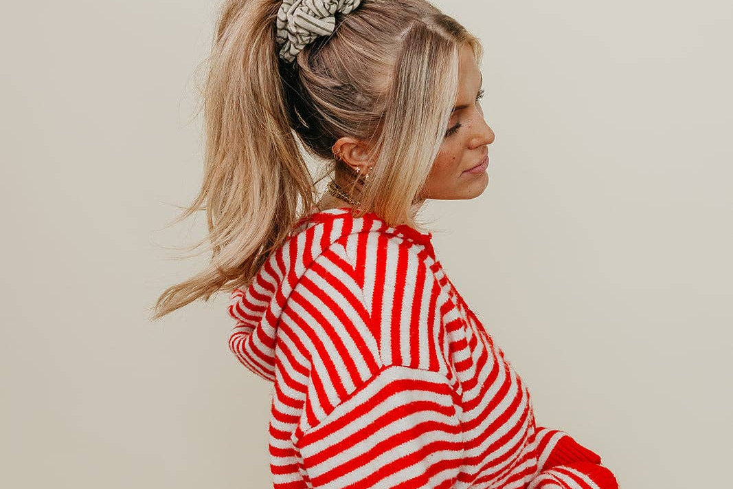 Woman wearing a red and white striped sweater against a plain background