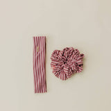 Pink striped headband and scrunchie set on a beige background