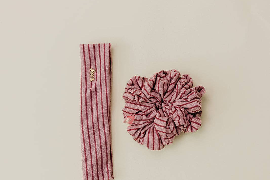 Pink striped headband and scrunchie set on a beige background