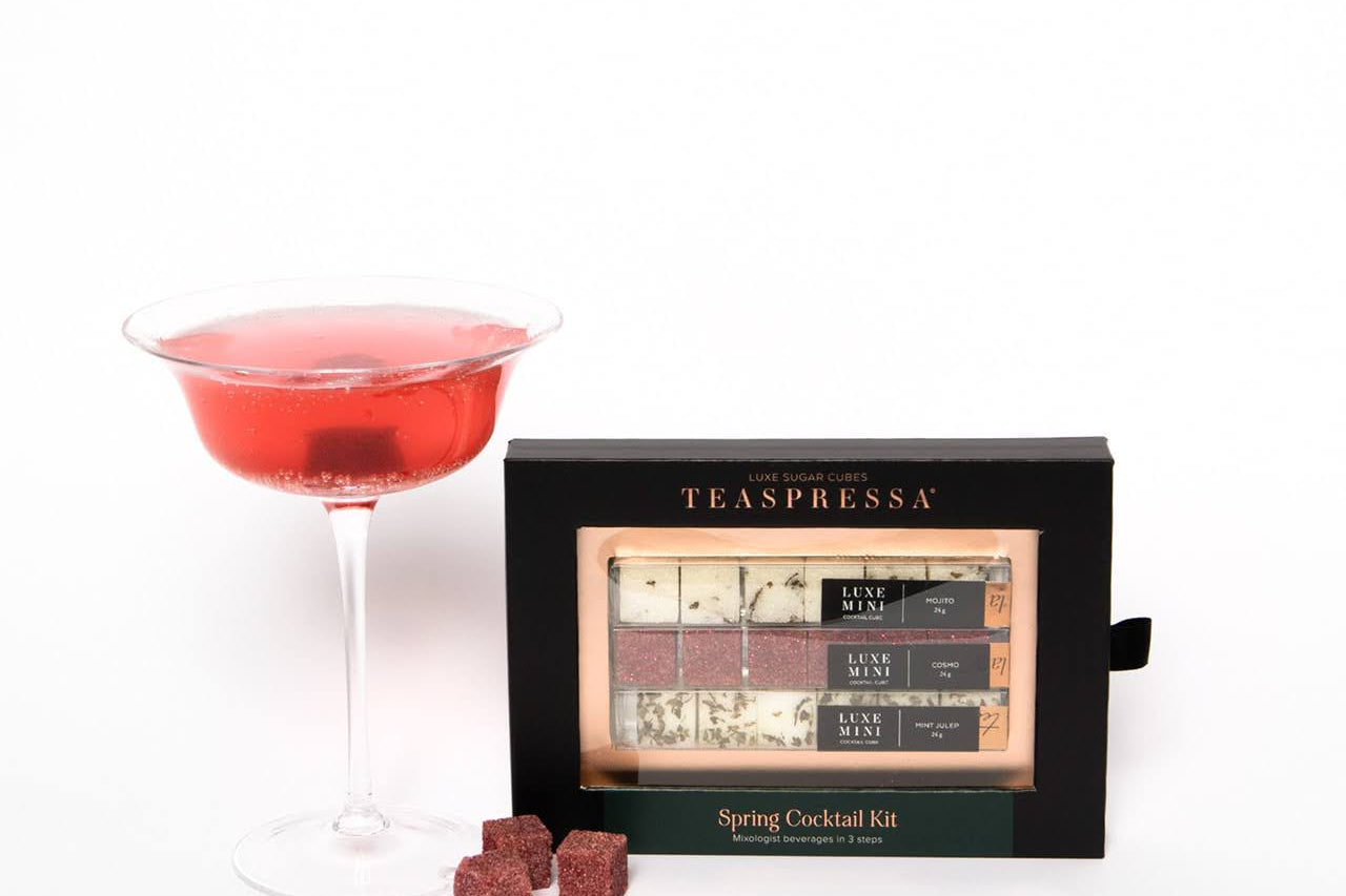 Luxe Mini Instant Cocktail Cubes by Teaspressa showing white and red cubes. Some cubes sitting outsite next to red cocktail drink. 