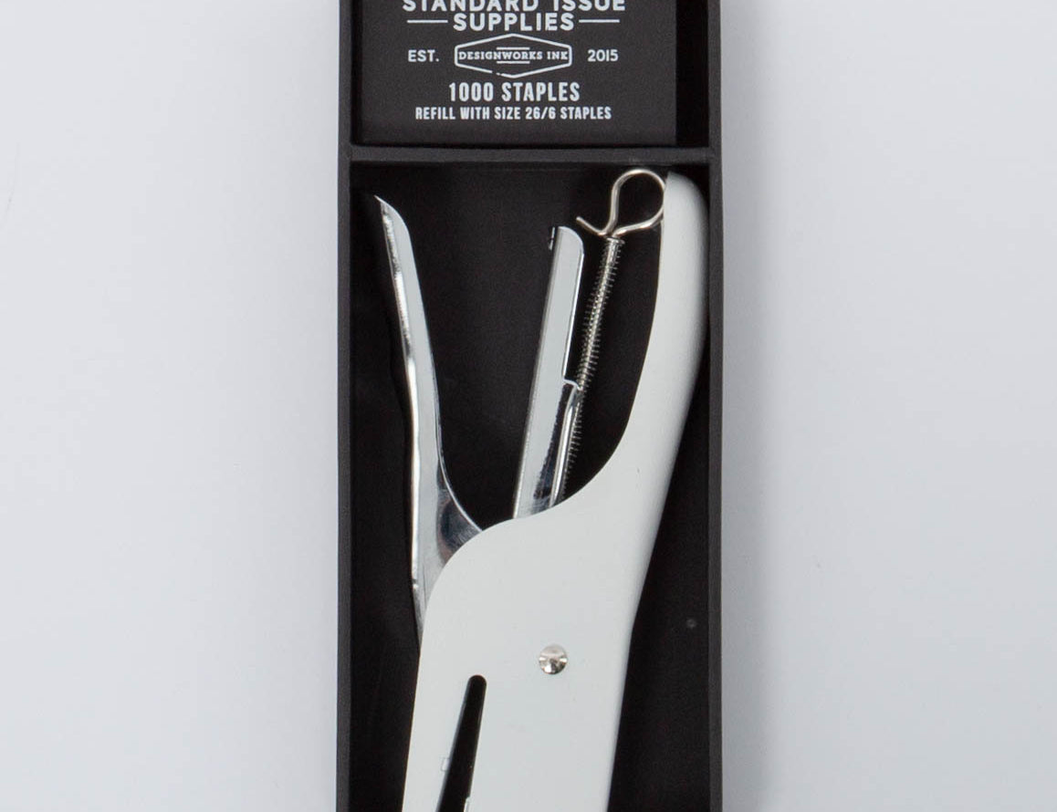 White and silver Standard Issue Stapler by Designworks in black packaging bog with 1000 staples. 