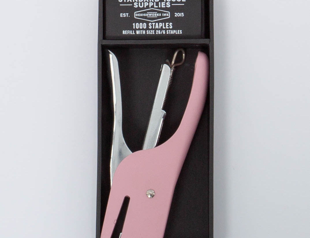 Pink and silver Standard Issue Stapler by Designworks in black packaging bog with 1000 staples. 