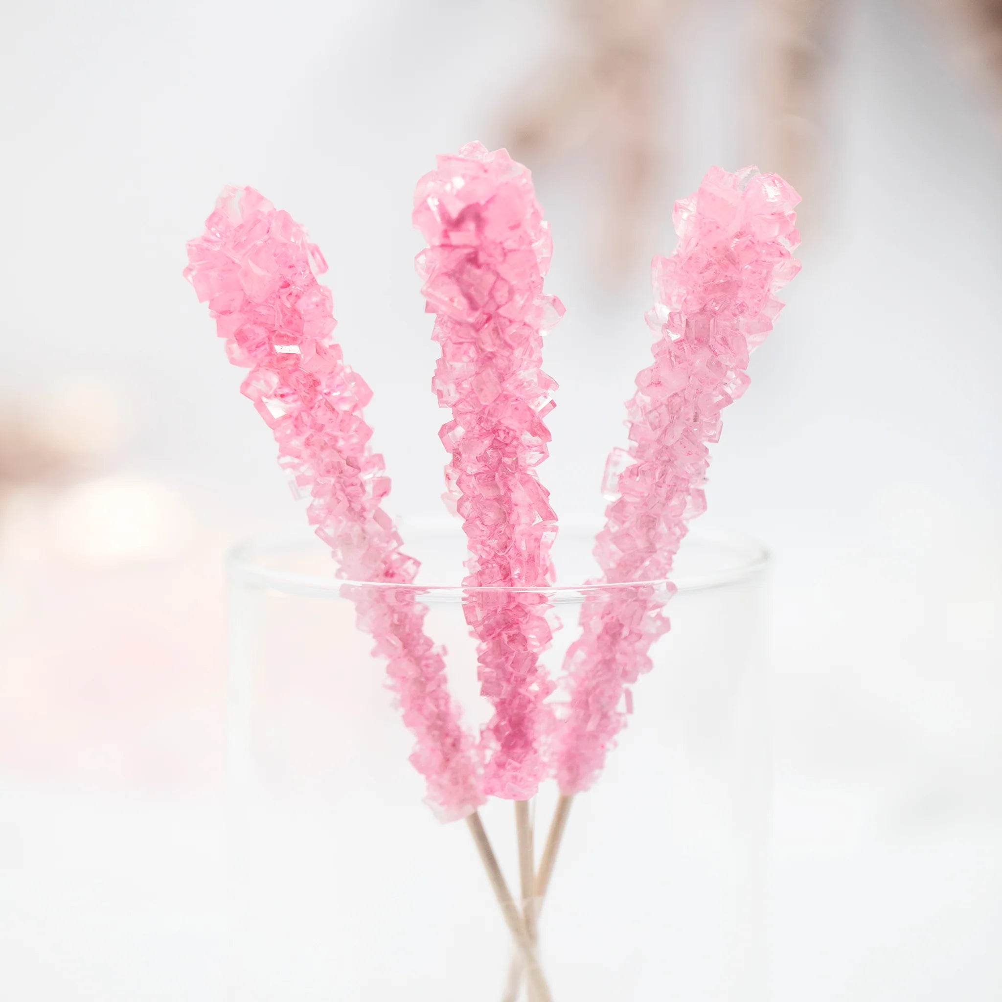 Three Nostalgic bubblegum flavored Think Pink Rock Candy by Lolli & Pops in clear class.