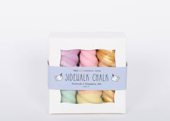 Box of TWEE Unicorn Narwhal Chalk. Three chalk pieces in gold, purple and green, and pink and yellow. White background. 