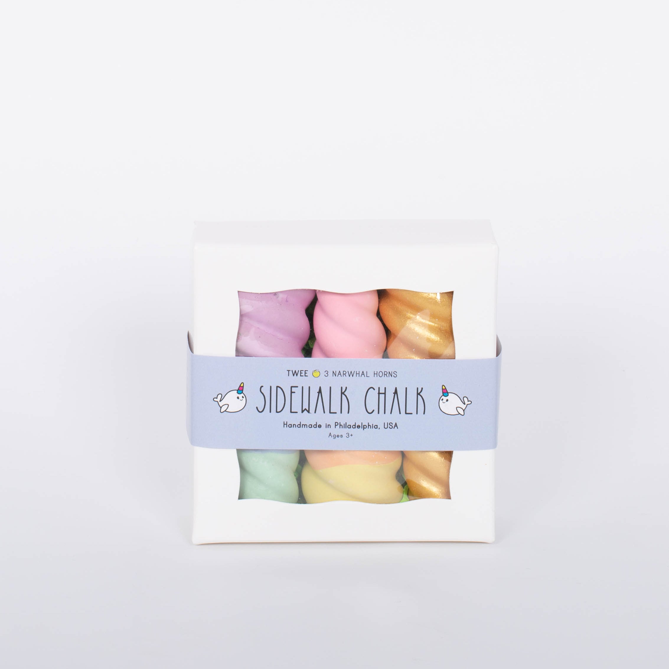 Box of TWEE Unicorn Narwhal Chalk. Three chalk pieces in gold, purple and green, and pink and yellow. White background. 