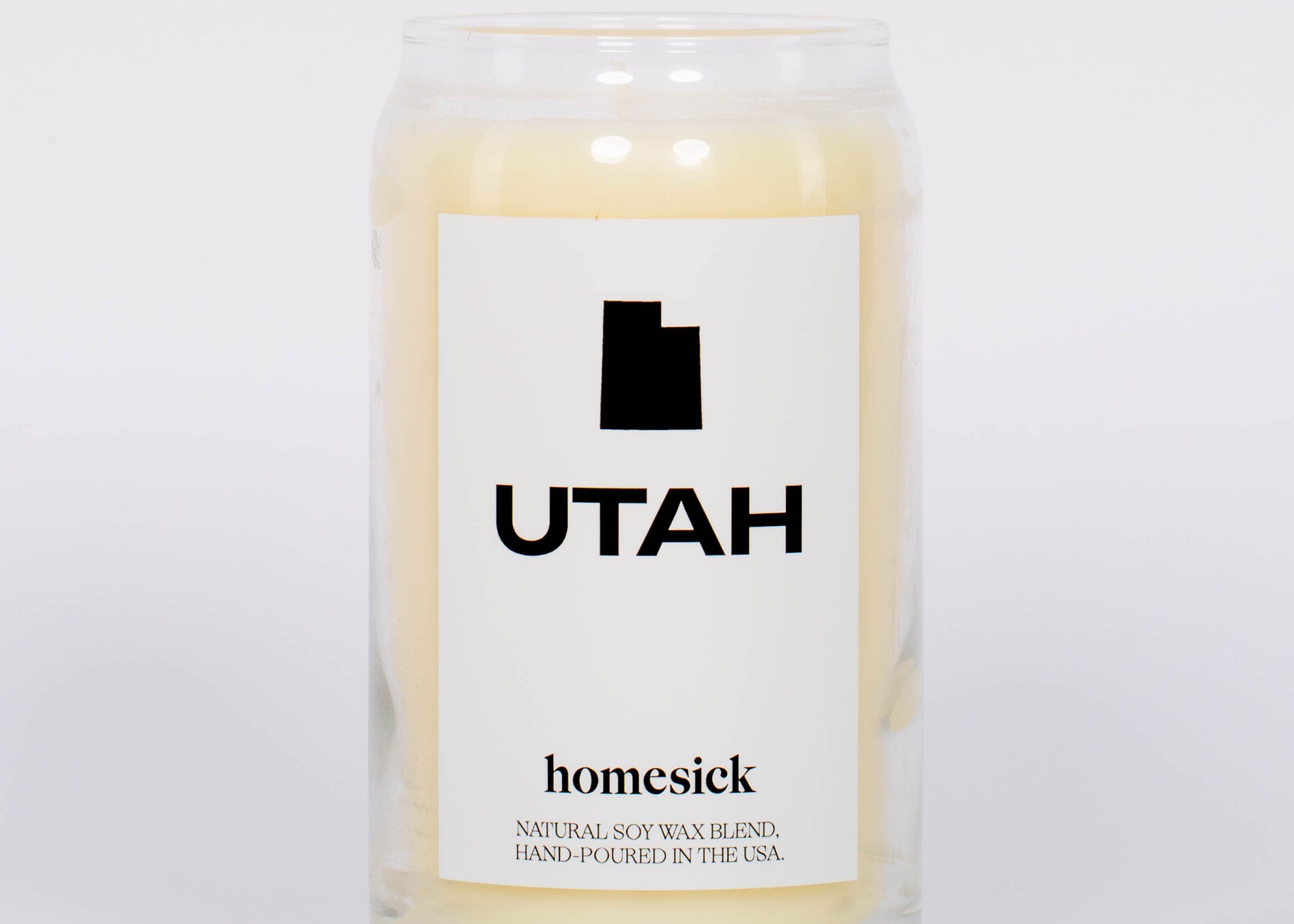 Cream soy wax hand poured Utah Candle by Homesick in glass jar and label with Utah state outline. 
