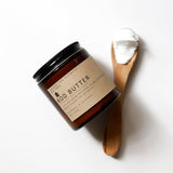 Among the Flowers Big Tree Bod Butter in an amber glass jar with a wooden spoon of whipped butter