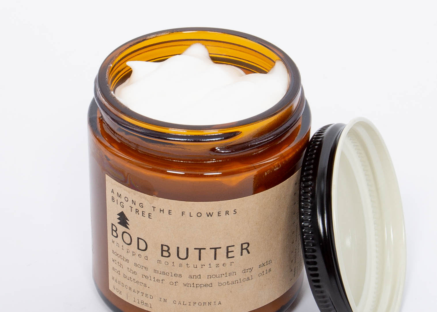Among the Flowers Big Tree Bod Butter open jar showing the whipped white butter with the lid beside it
