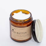 Among the Flowers Big Tree Bod Butter open jar showing the whipped white butter with the lid beside it