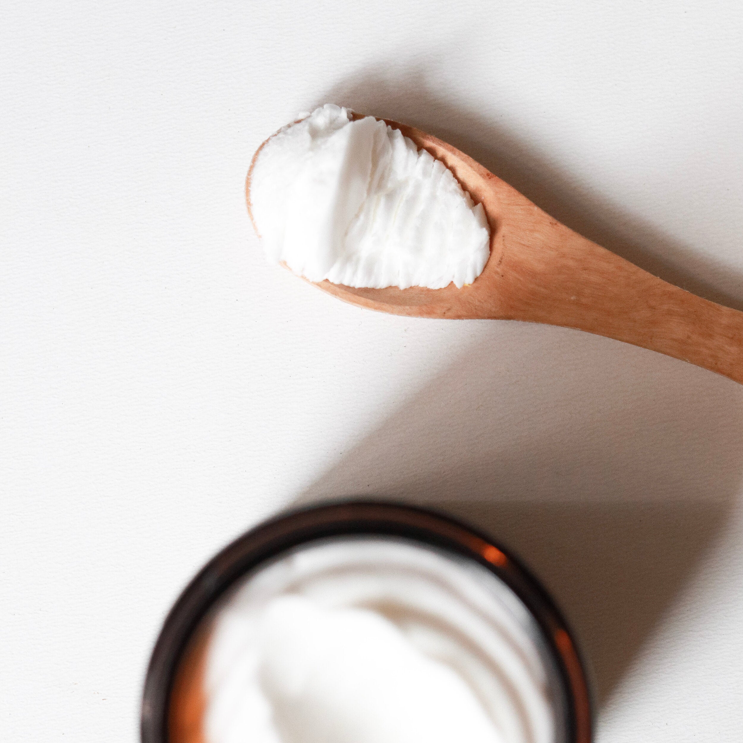 Wooden spoon scooping white whipped Among the Flowers Big Tree Bod Butter from the open jar
