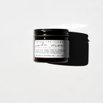 Among the Flowers Calm Mom Breast Salve in a small amber glass jar with a black lid