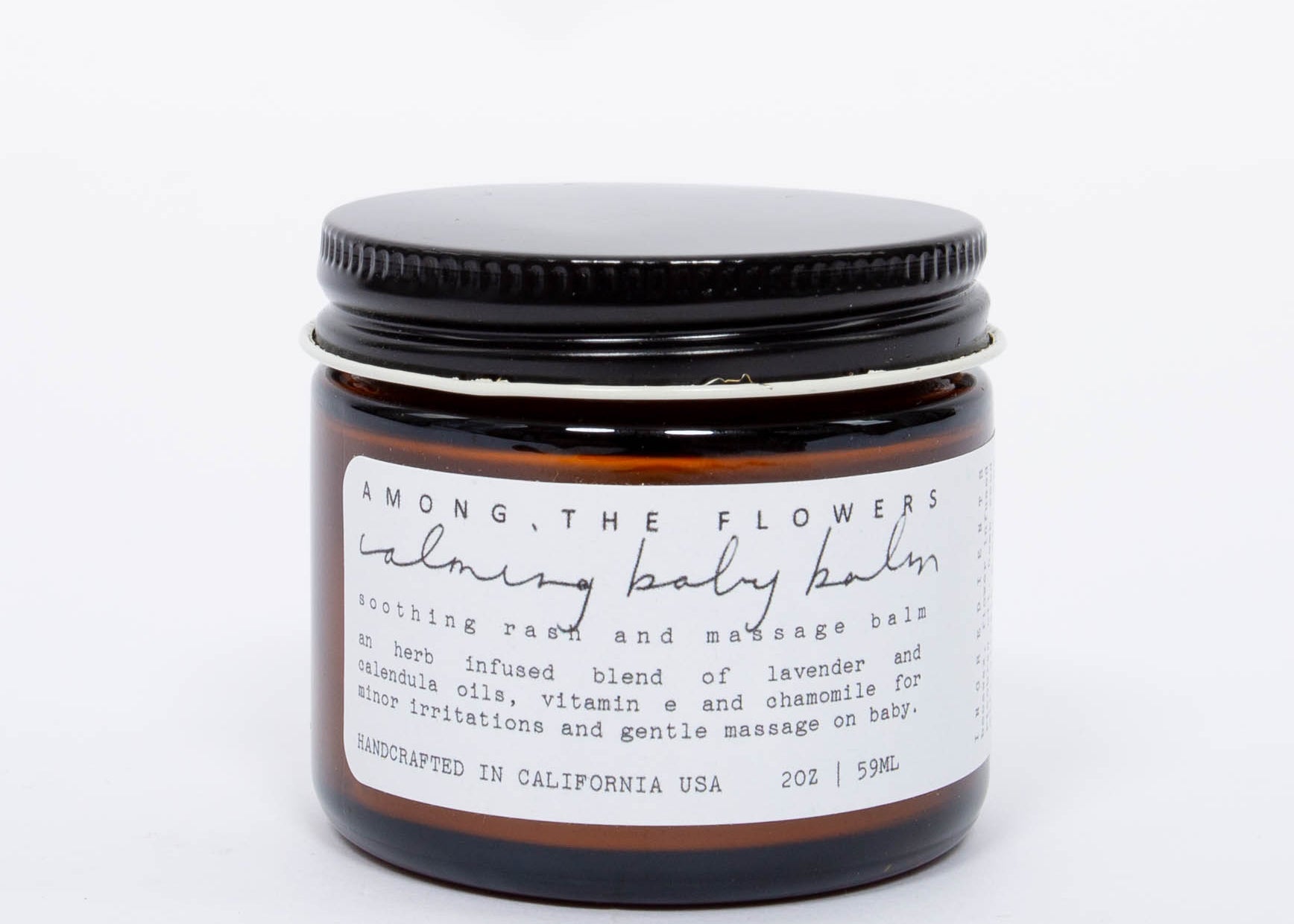 Among the Flowers Calming Baby Balm in an amber glass jar with a black lid and white label