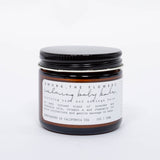 Among the Flowers Calming Baby Balm in an amber glass jar with a black lid and white label