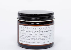 Among the Flowers Calming Baby Balm in an amber glass jar with a black lid and white label
