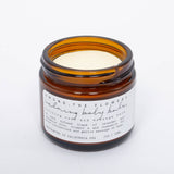 Among the Flowers Calming Baby Balm open amber jar showing the pale yellow balm