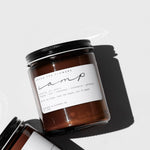 Among the Flowers Camp Candle in an amber glass jar with a black lid and white label