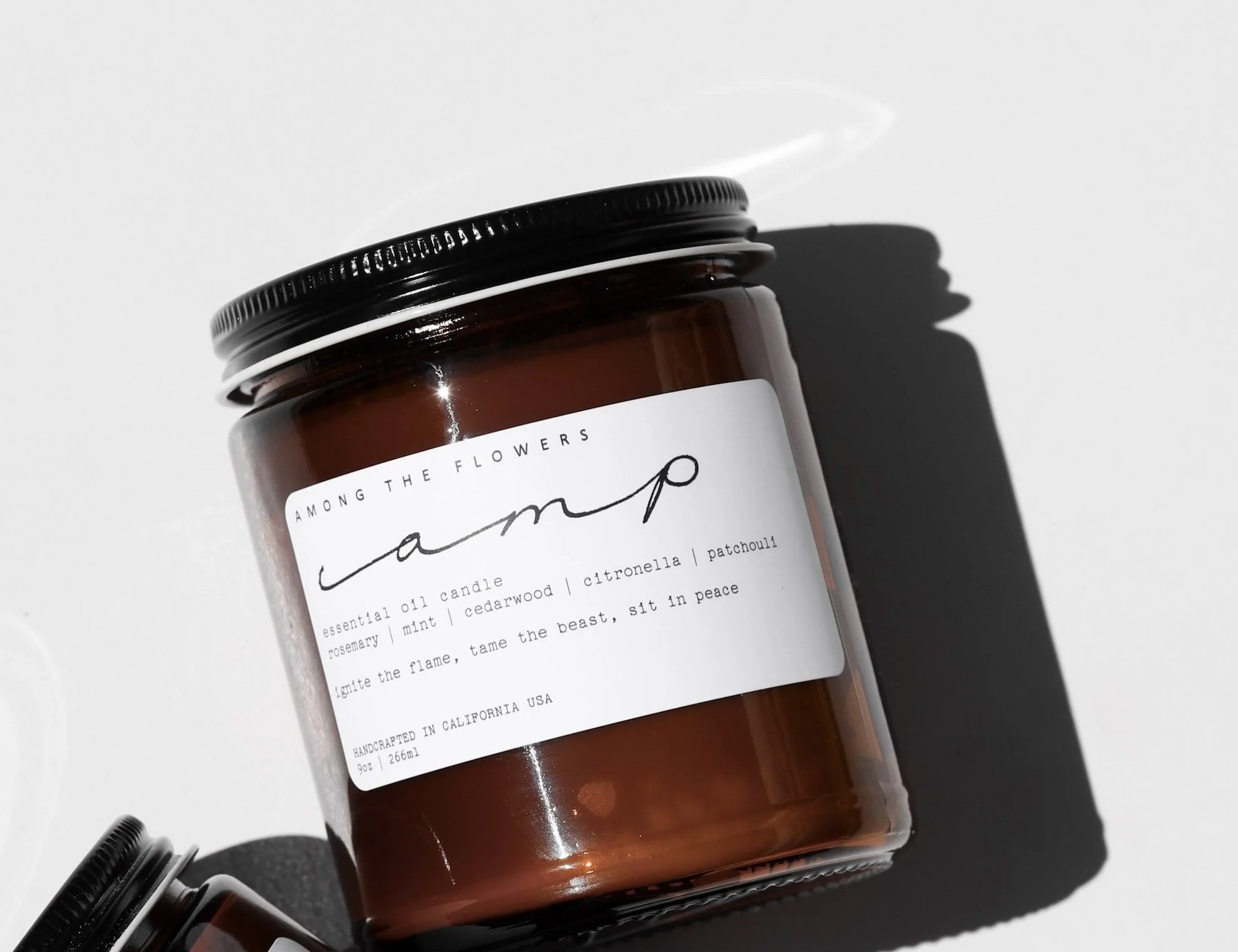Among the Flowers Camp Candle in an amber glass jar with a black lid and white label