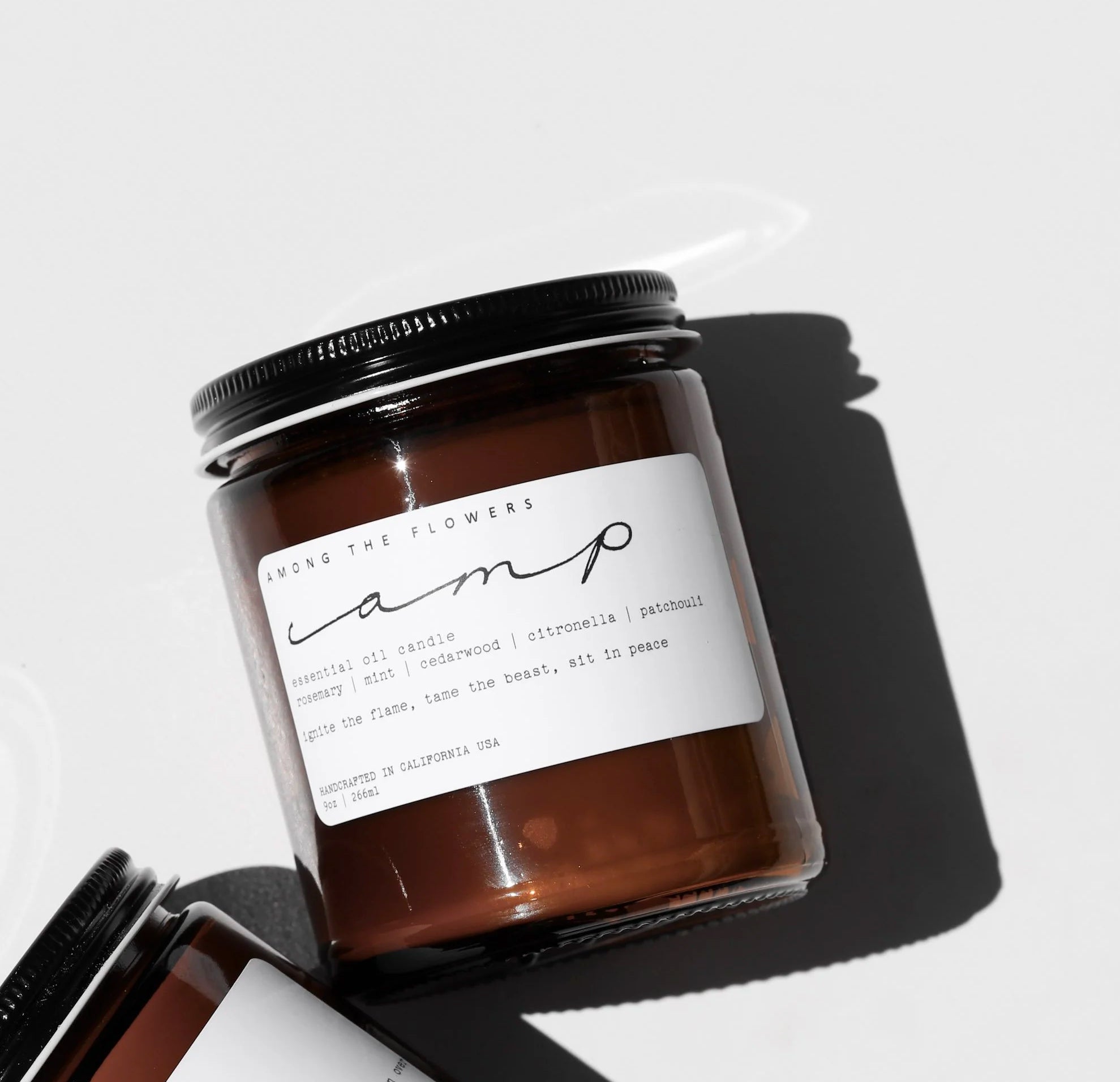 Among the Flowers Camp Candle in an amber glass jar with a black lid and white label
