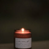 Among the Flowers Camp Candle lit and glowing in a dark room