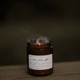 Among the Flowers Camp Candle with smoke rising from the wick after being blown out