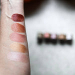 Among the Flowers Lip and Cheek Tint shades swatched on an arm beside the tubes
