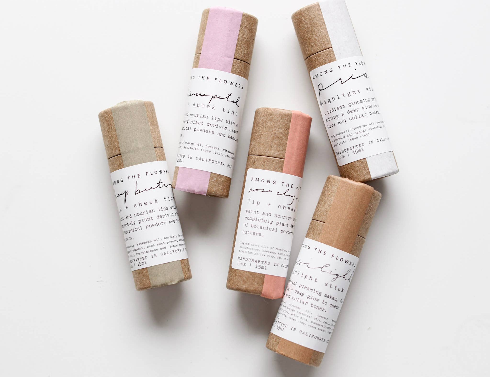 Among the Flowers Lip and Cheek Tints in kraft paper tubes with cream labels, laid out in a group
