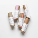 Among the Flowers Lip and Cheek Tints in kraft paper tubes with cream labels, laid out in a group
