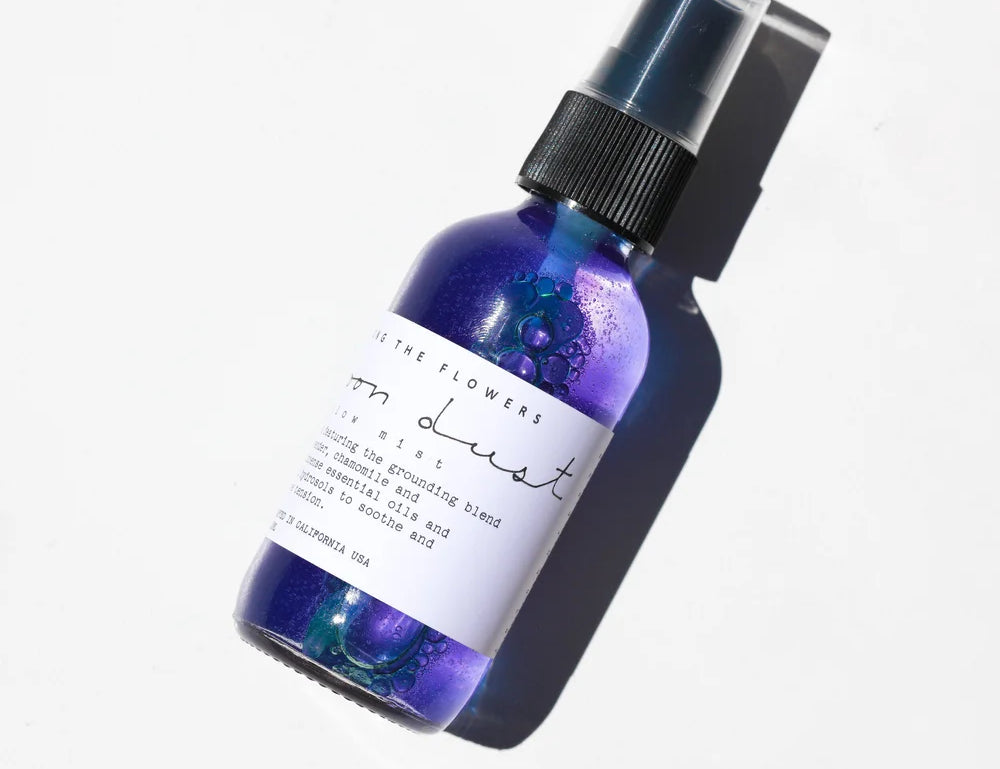 Among the Flowers Moon Dust Pillow Mist in a purple glass spray bottle