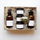 Among the Flowers New Mom + Babe Kit, amber bottles and jars nestled in a wooden gift box with straw