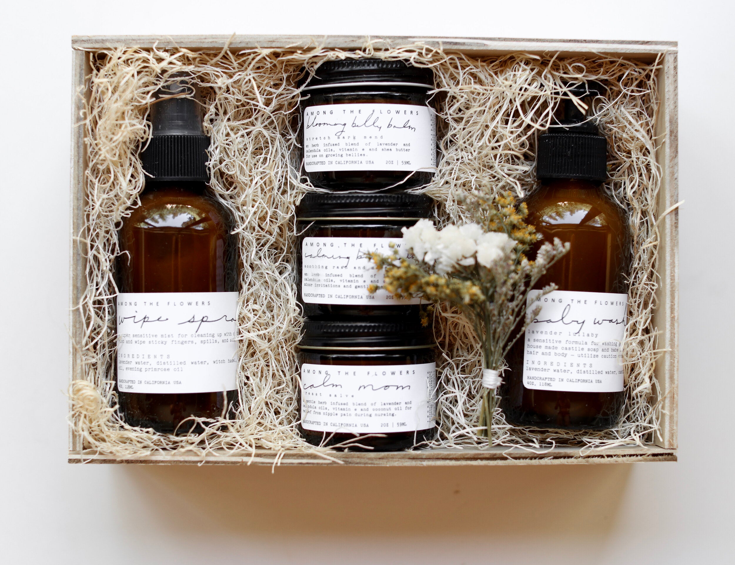 Among the Flowers New Mom + Babe Kit, amber bottles and jars nestled in a wooden gift box with straw