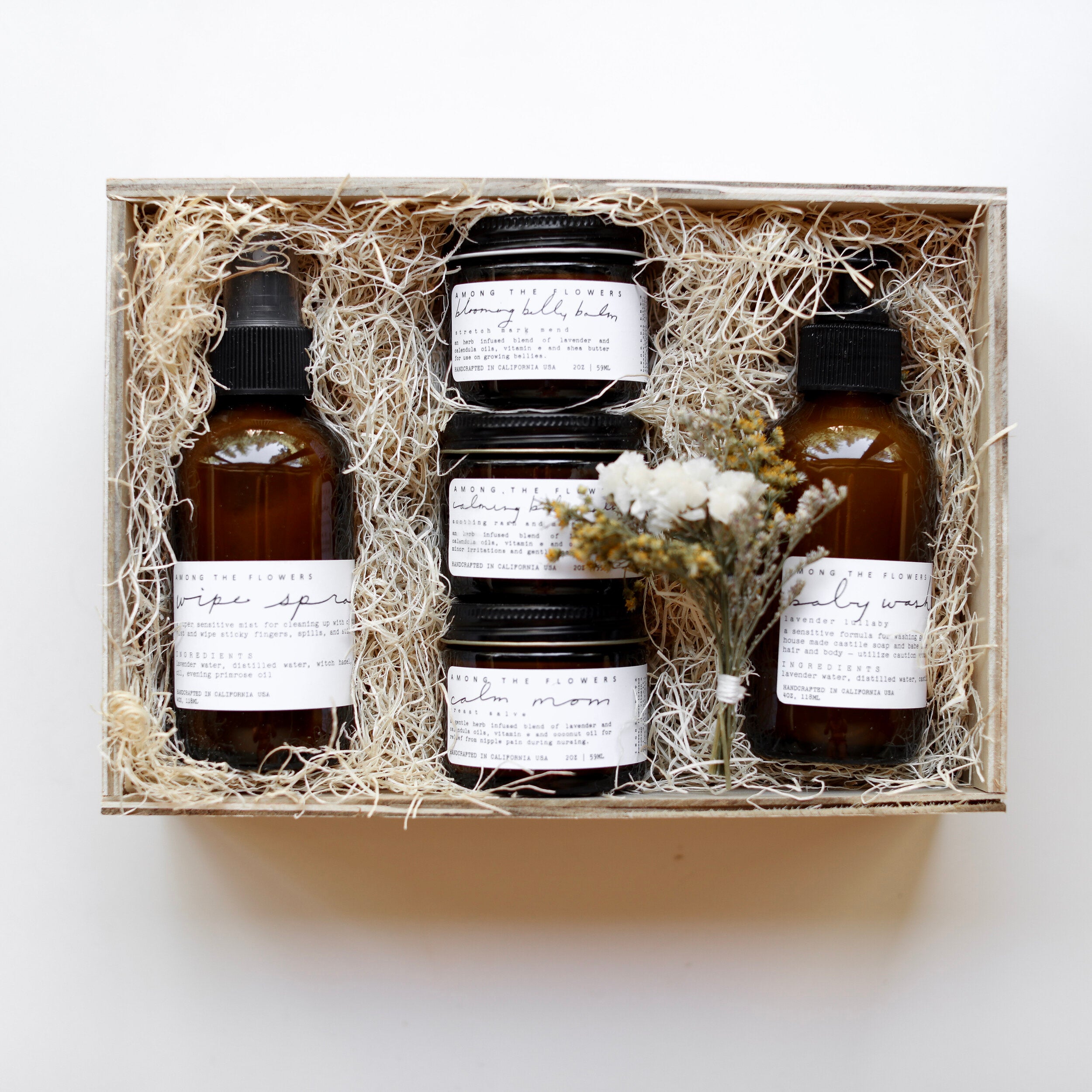 Among the Flowers New Mom + Babe Kit, amber bottles and jars nestled in a wooden gift box with straw
