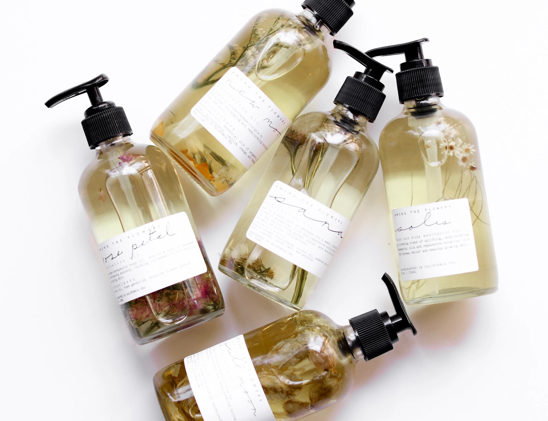 Several Among the Flowers botanical oil pump bottles laid out together from above